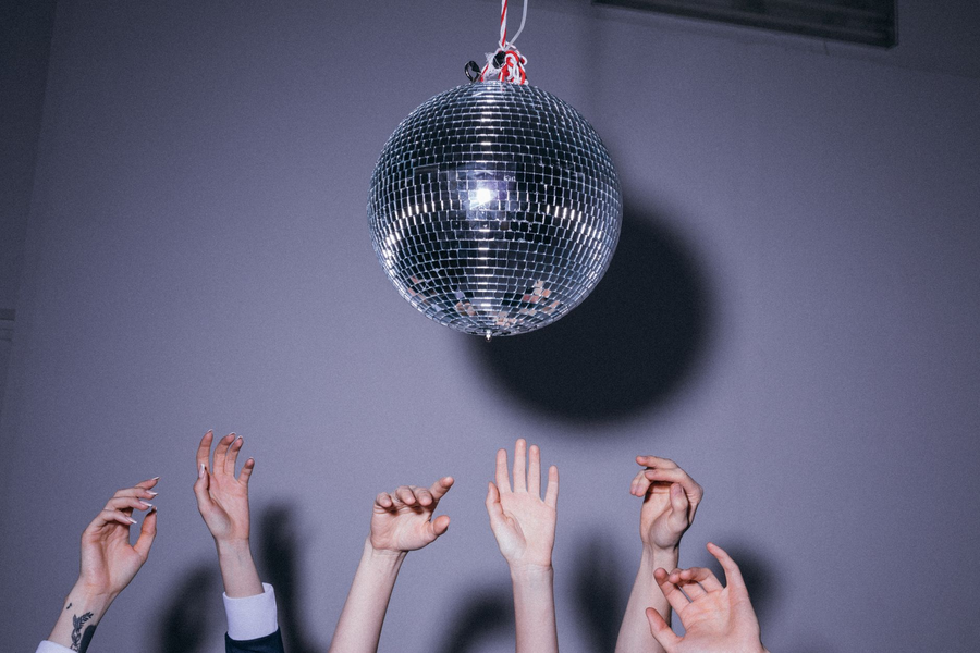People dancing at a retro disco party under colourful lights