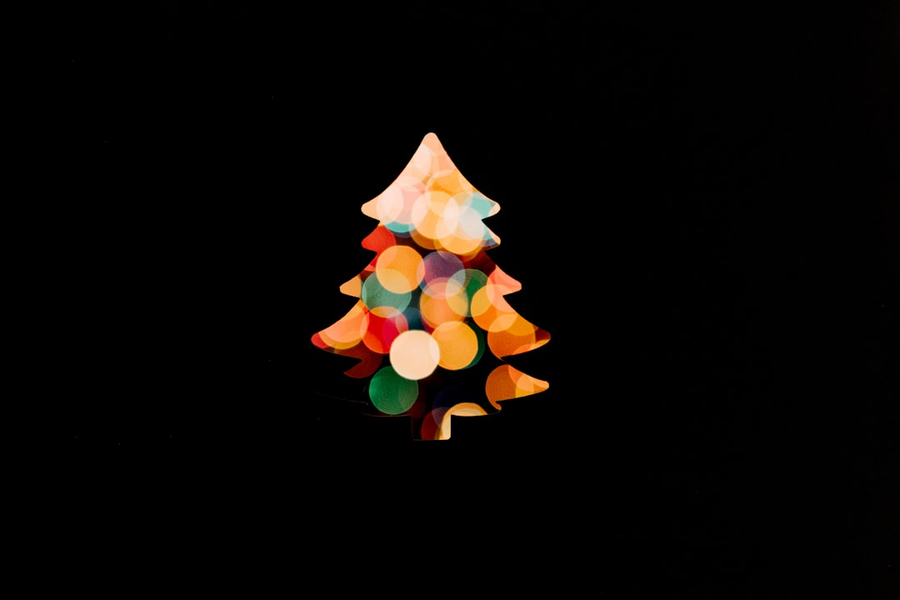 Children celebrating around a decorated Christmas tree